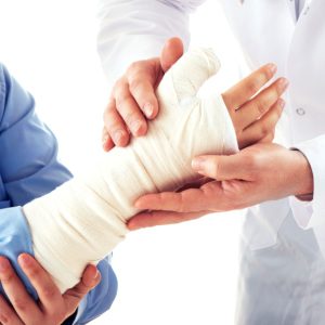 A doctor treating a patient with a bandaged hand and wrist following an injury in Gloucester