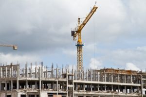 A large crane next to a construction site of a multi-story building.