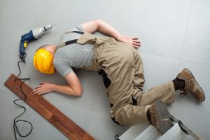 A construction worker lying on the ground unconscious.