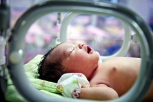 A baby lying in an incubator.