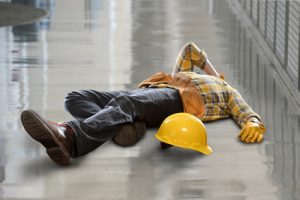 An injured worker lying on a wet floor