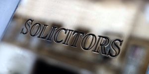 A metal sign that has the word solicitors engraved into it