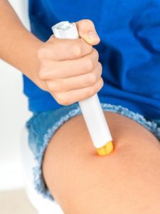 A person using an emergency injection in their leg
