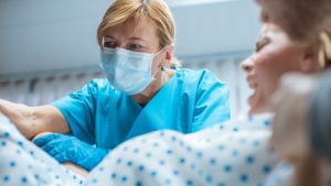 A woman giving birth while a doctor assists.
