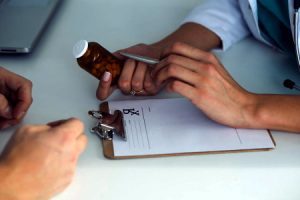 A doctor prescribing medication to a patient and checking for drug allergic reaction