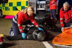 Paramedics tending to a rider following a motorcycle accident without insurance