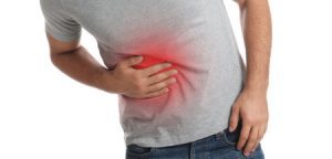 Man holding ribs in pain due to an injury