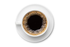 Black coffee in a white mug on a saucer.