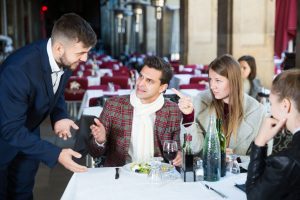 Three unhappy restaurant customers complaining to a member of staff