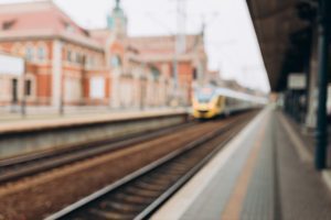 A blurry image of a train station with a train approaching the platform.