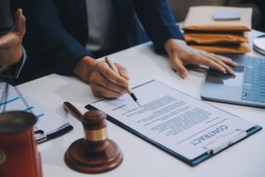 Endometriosis solicitor reviewing a contract at a desk with a gavel and laptop.