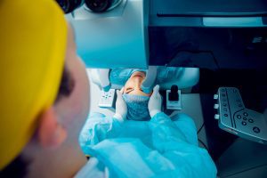 A woman receives negligent eye treatment during cataract surgery while wearing a hospital gown.