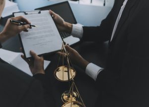 Solicitors examining paperwork during a meeting with a set of justice scales in the foreground
