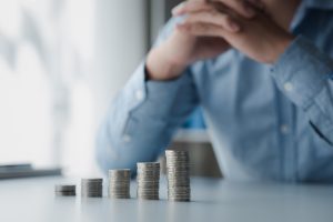 A man sitting behind stacks of coins