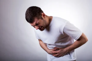 A man holding his stomach in pain due to abdominal injury