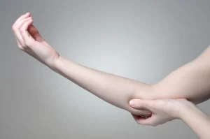 Woman holding her elbow in pain